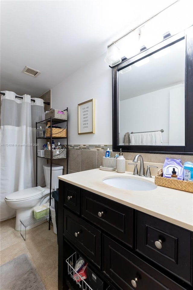 bathroom with vanity, tile walls, and toilet