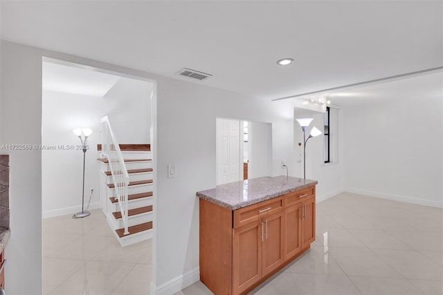 kitchen featuring light tile patterned flooring and light stone countertops