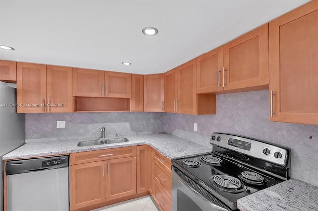 kitchen featuring light stone counters, stainless steel appliances, sink, and decorative backsplash