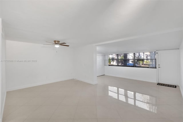 tiled spare room with ceiling fan