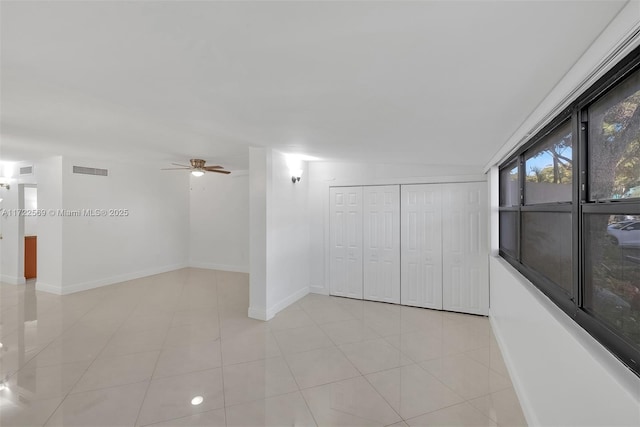 tiled spare room with ceiling fan