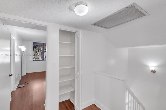 walk in closet with hardwood / wood-style flooring and lofted ceiling