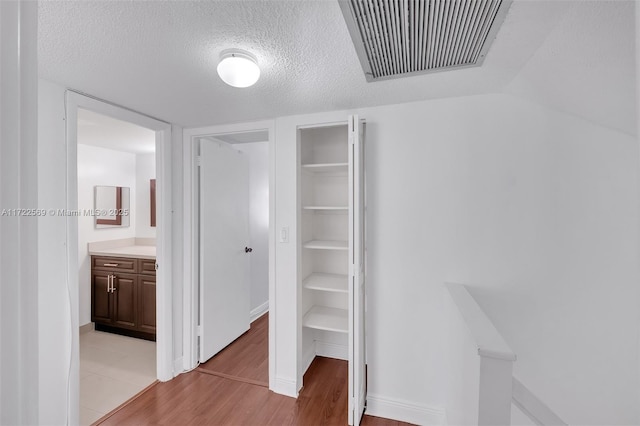 interior space featuring light hardwood / wood-style floors and a textured ceiling