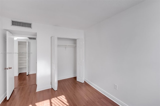 unfurnished bedroom featuring hardwood / wood-style floors and a closet