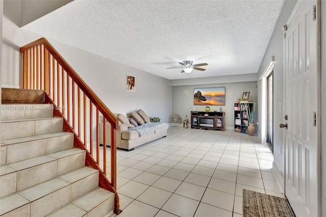 unfurnished living room featuring light tile patterned floors, a textured ceiling, and ceiling fan