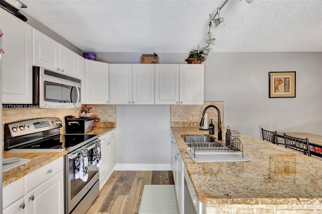 kitchen with backsplash, white cabinetry, a textured ceiling, and appliances with stainless steel finishes