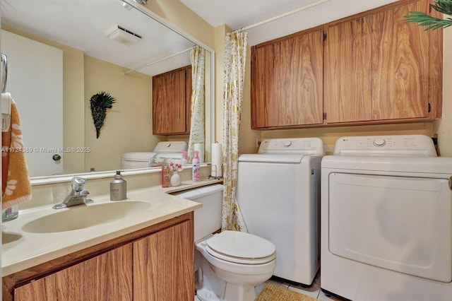 bathroom featuring washer and clothes dryer, vanity, and toilet