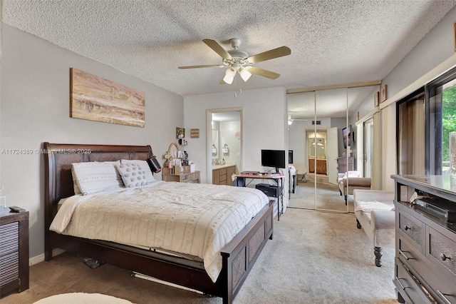 bedroom featuring ceiling fan, light colored carpet, and a textured ceiling