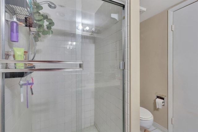 bathroom featuring toilet and a shower with shower door