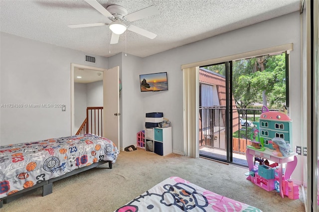 carpeted bedroom with access to exterior, ceiling fan, and a textured ceiling