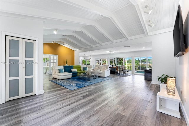 living room with hardwood / wood-style flooring, french doors, and vaulted ceiling with beams