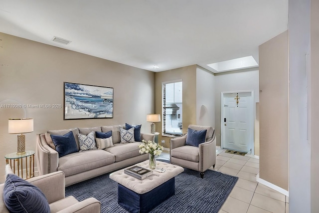 living room featuring a skylight and light tile patterned floors