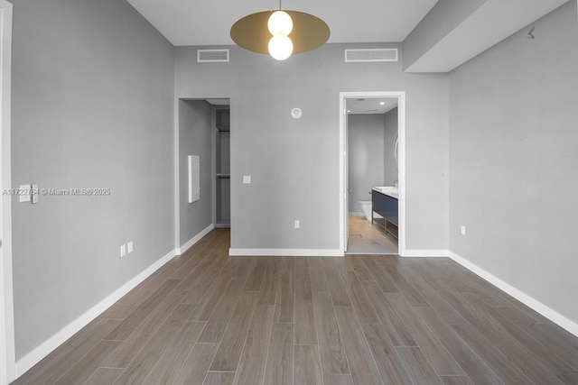 2655 S Bayshore Dr Unit 1212, Coconut Grove, FL 33133 - unfurnished bedroom with a walk in closet, wood finished floors, visible vents, and baseboards