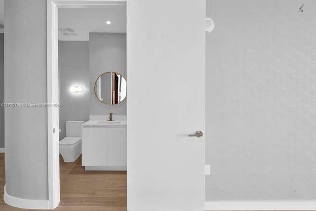 bathroom featuring hardwood / wood-style flooring, vanity, and toilet