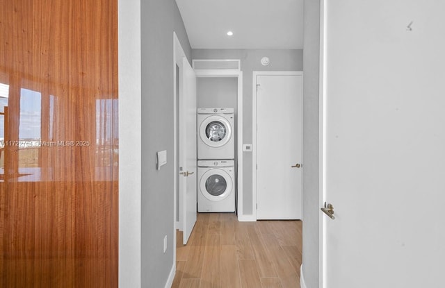 2655 S Bayshore Dr Unit 1212, Coconut Grove, FL 33133 - clothes washing area featuring baseboards, wood finished floors, stacked washing maching and dryer, and laundry area