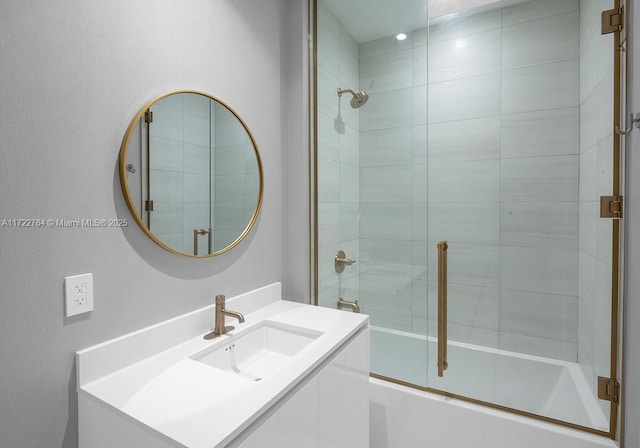 bathroom with bath / shower combo with glass door and vanity