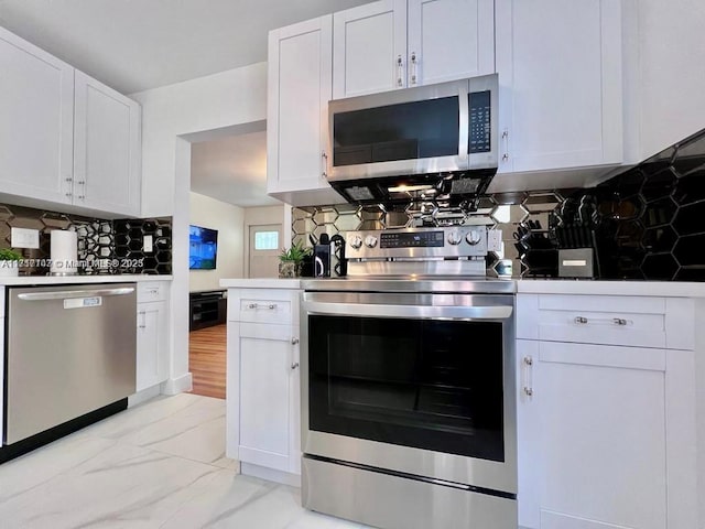 kitchen featuring white cabinets, backsplash, and stainless steel appliances