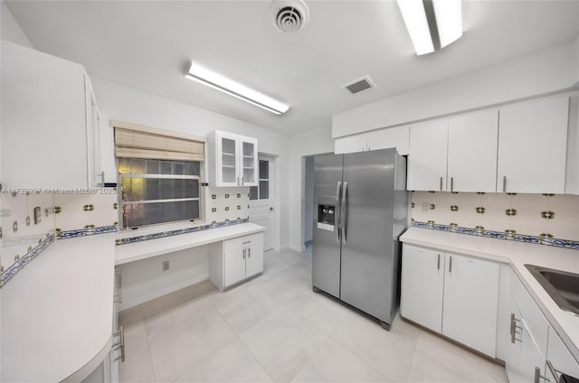 kitchen featuring white cabinets, sink, decorative backsplash, light tile patterned floors, and stainless steel fridge with ice dispenser