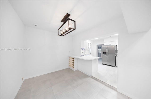 kitchen with white cabinets, kitchen peninsula, and stainless steel refrigerator with ice dispenser