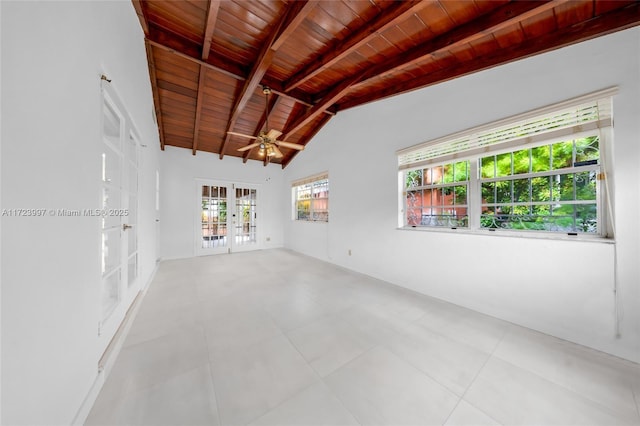 empty room featuring french doors, lofted ceiling with beams, ceiling fan, and wooden ceiling