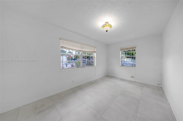 tiled spare room with a textured ceiling