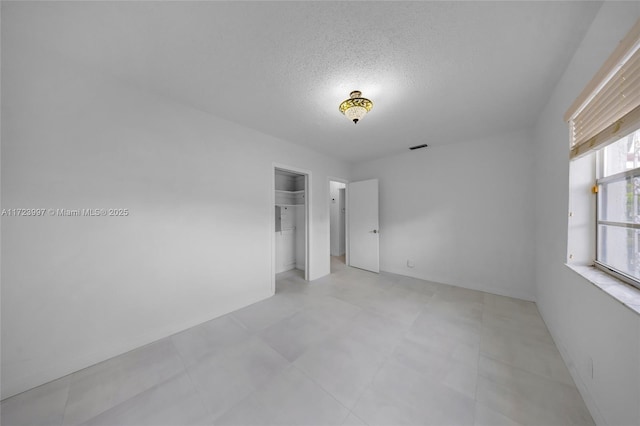 unfurnished room featuring a textured ceiling