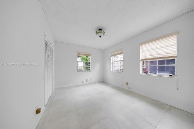 unfurnished room with a textured ceiling