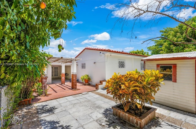 back of property featuring a pergola and a patio