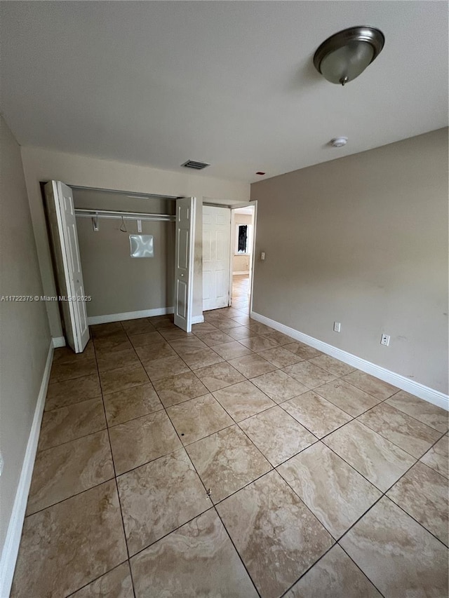 unfurnished bedroom featuring light tile patterned floors and a closet