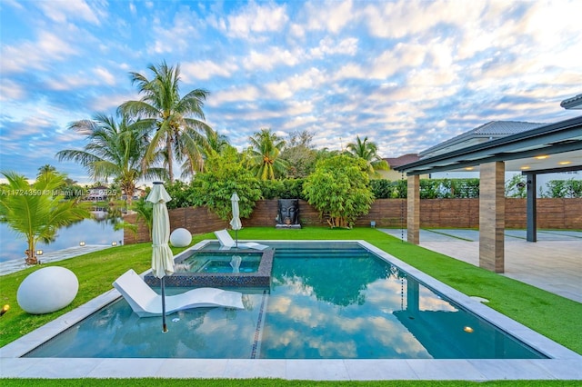 view of pool featuring a water view, a yard, and an in ground hot tub