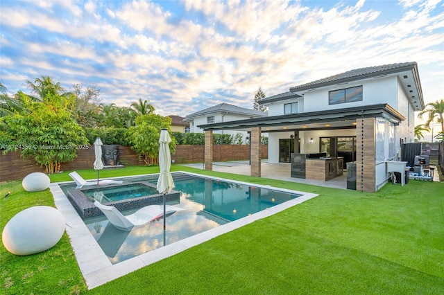 rear view of property featuring a patio area, a yard, a pool with hot tub, area for grilling, and a bar