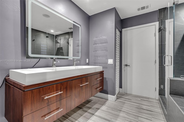 bathroom featuring hardwood / wood-style flooring, vanity, and an enclosed shower