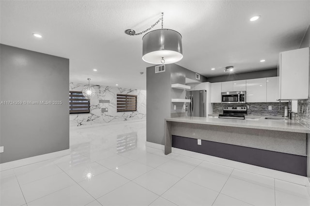 kitchen featuring kitchen peninsula, appliances with stainless steel finishes, sink, decorative light fixtures, and white cabinets