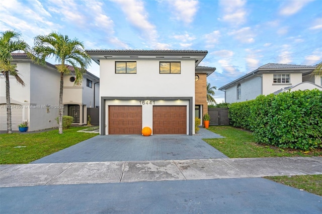 view of front of home with a garage and a front lawn