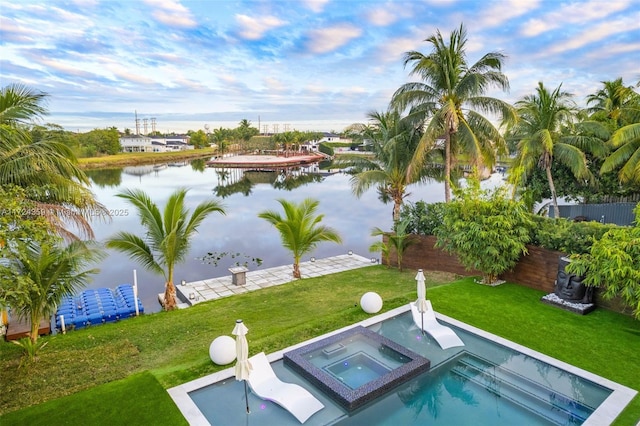 view of swimming pool with a water view, a yard, and an in ground hot tub