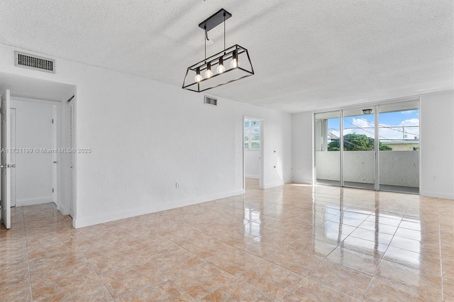 tiled spare room with a textured ceiling