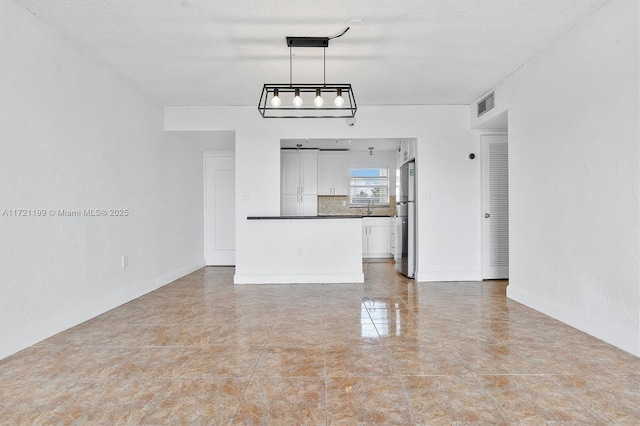 unfurnished living room featuring sink and a textured ceiling