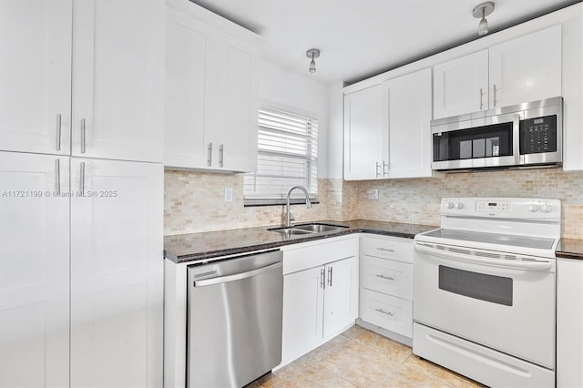 kitchen featuring white cabinetry, stainless steel appliances, light tile patterned flooring, and sink