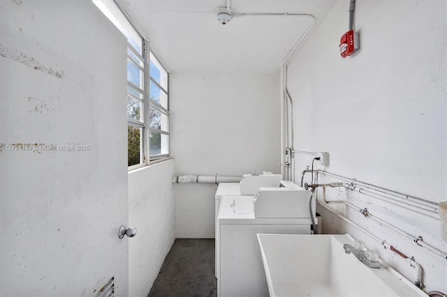 clothes washing area featuring washer / clothes dryer and sink