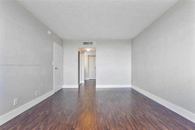 unfurnished room featuring a textured ceiling and dark wood-type flooring