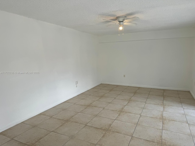 unfurnished room featuring ceiling fan, light tile patterned floors, and a textured ceiling