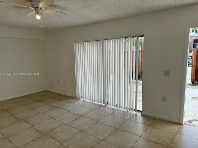 spare room with light tile patterned floors, a textured ceiling, and ceiling fan