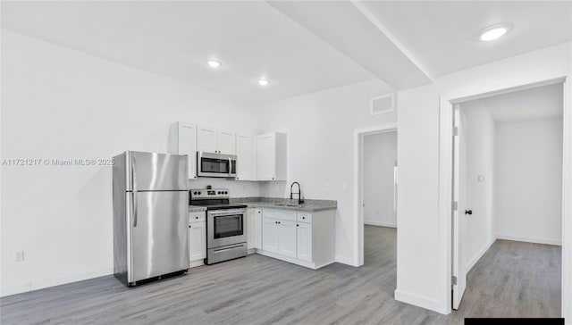 kitchen featuring white cabinets, light wood-type flooring, sink, and appliances with stainless steel finishes