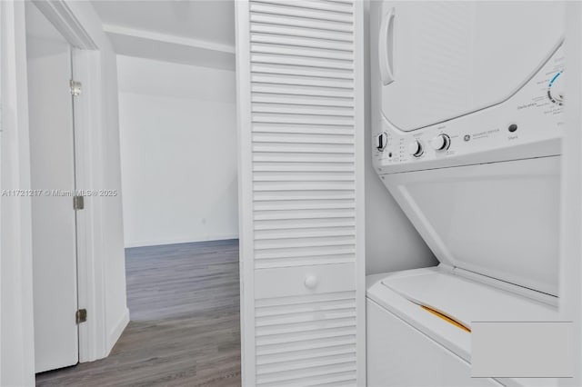 laundry room with stacked washer and dryer and light hardwood / wood-style flooring