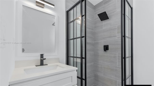 bathroom featuring a tile shower and vanity