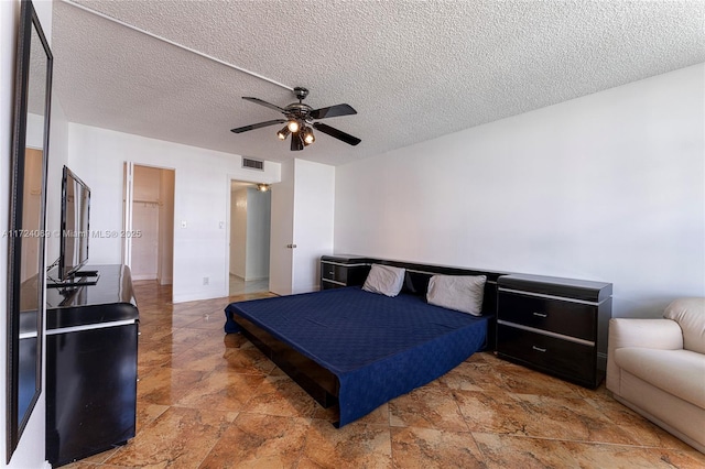 bedroom with a textured ceiling and ceiling fan