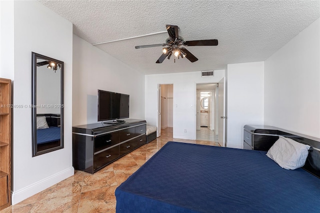 bedroom with ceiling fan and a textured ceiling