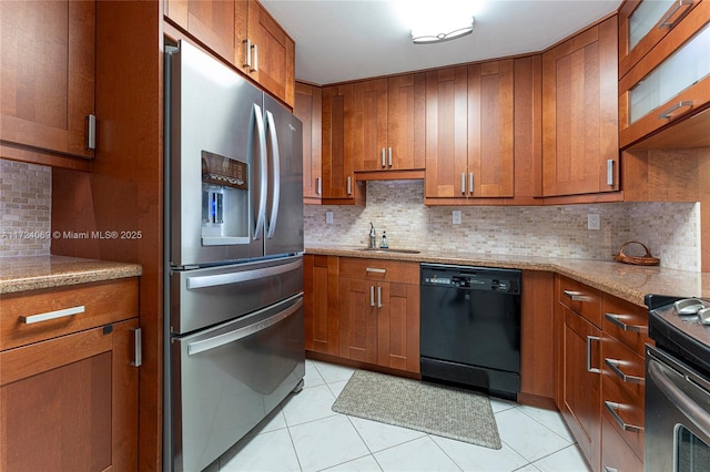 kitchen featuring sink, light stone counters, decorative backsplash, and appliances with stainless steel finishes