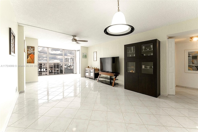 unfurnished living room featuring ceiling fan and a textured ceiling