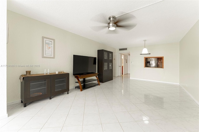 tiled living room featuring ceiling fan and a textured ceiling